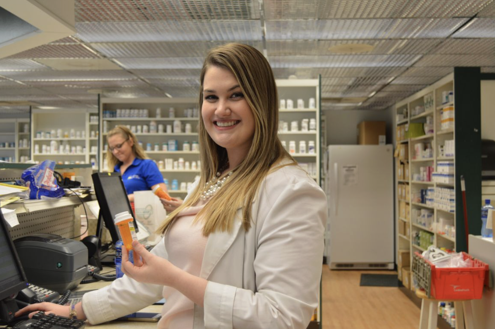 A pharmacist speaks to a patient at the counter Medication therapy management